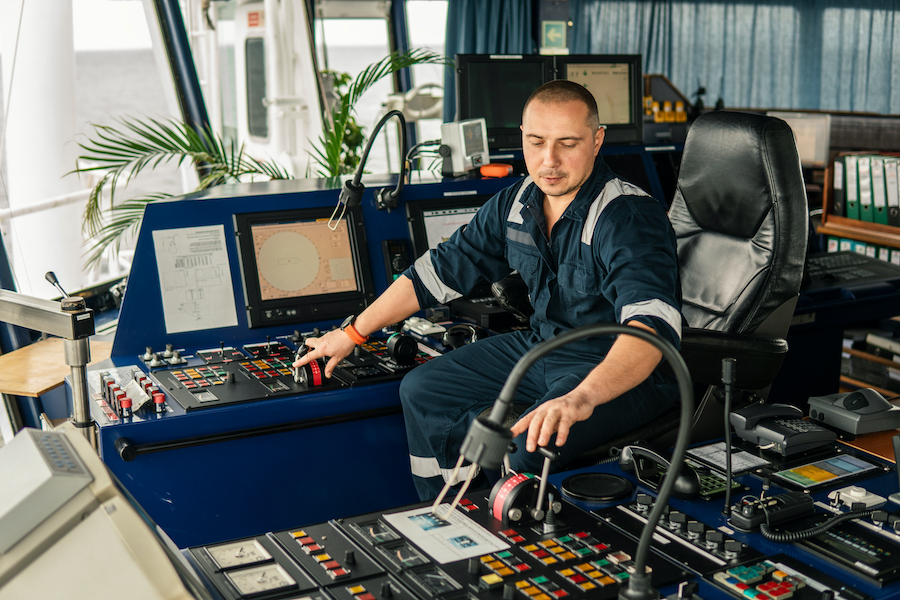 Marine navigational officer is maneuvering ship or vessel